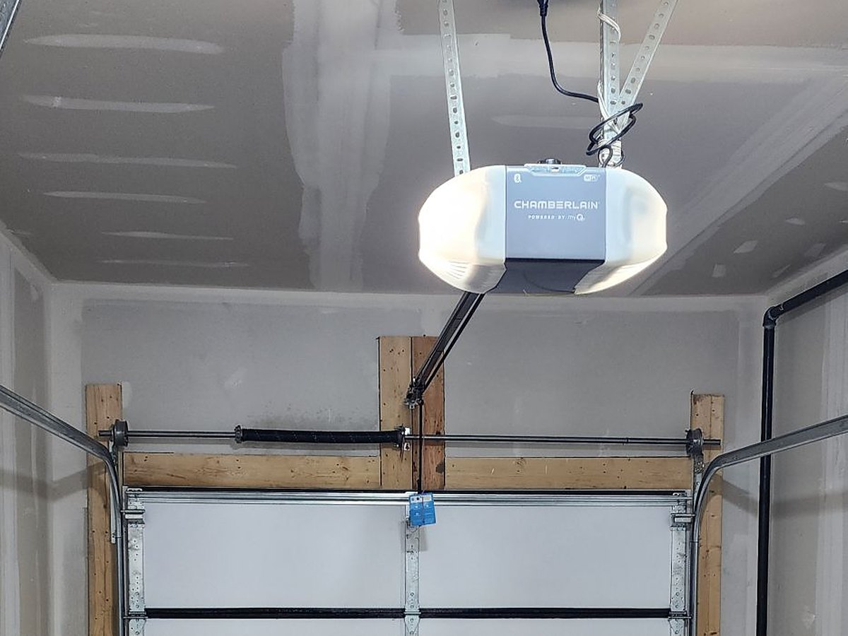 Opener mounted to a finished garage ceiling, the rail running forward to the door arm at the top section